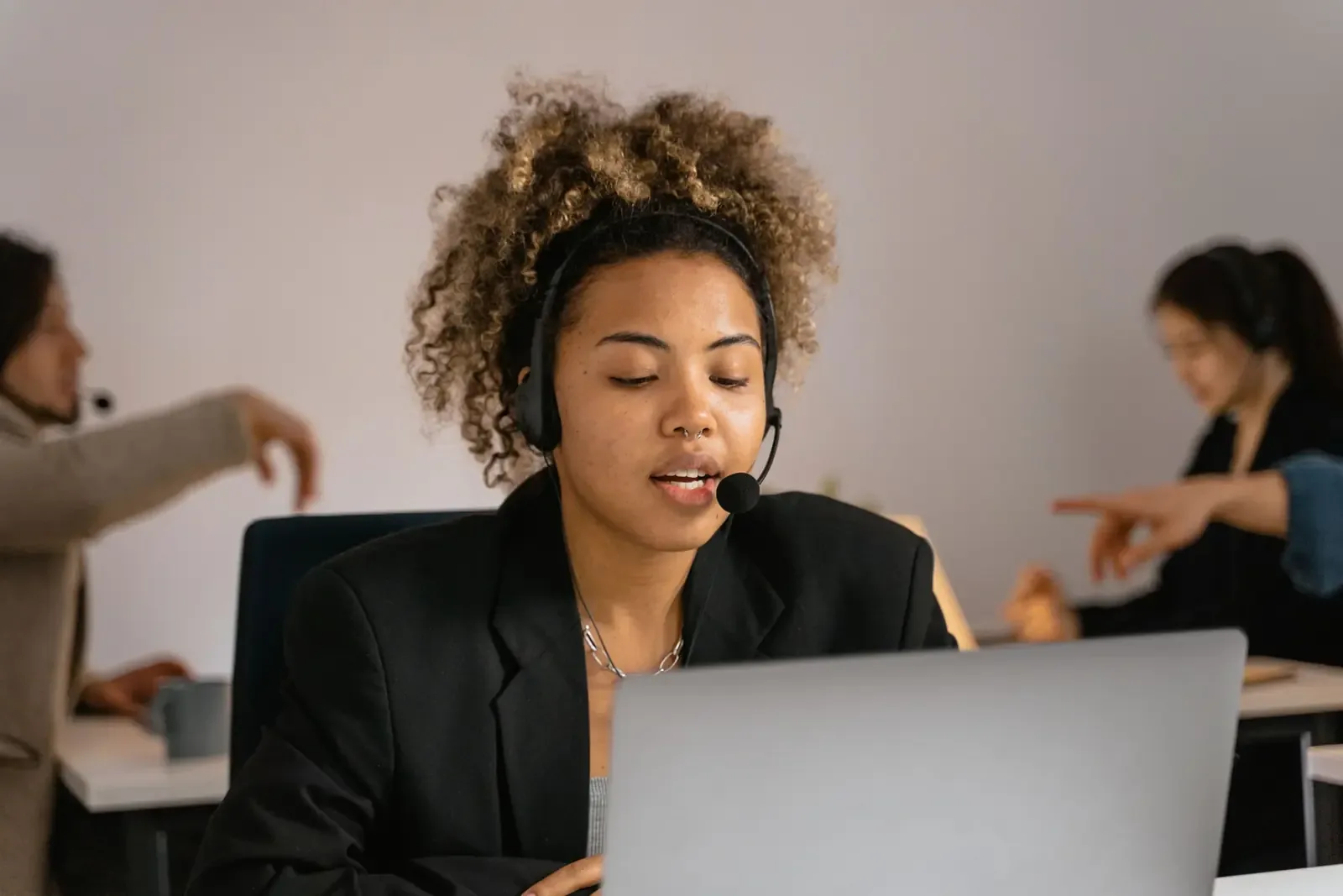 Conseillère d'AT en cours d'appel, casque sur les oreilles, devant son poste de travail.